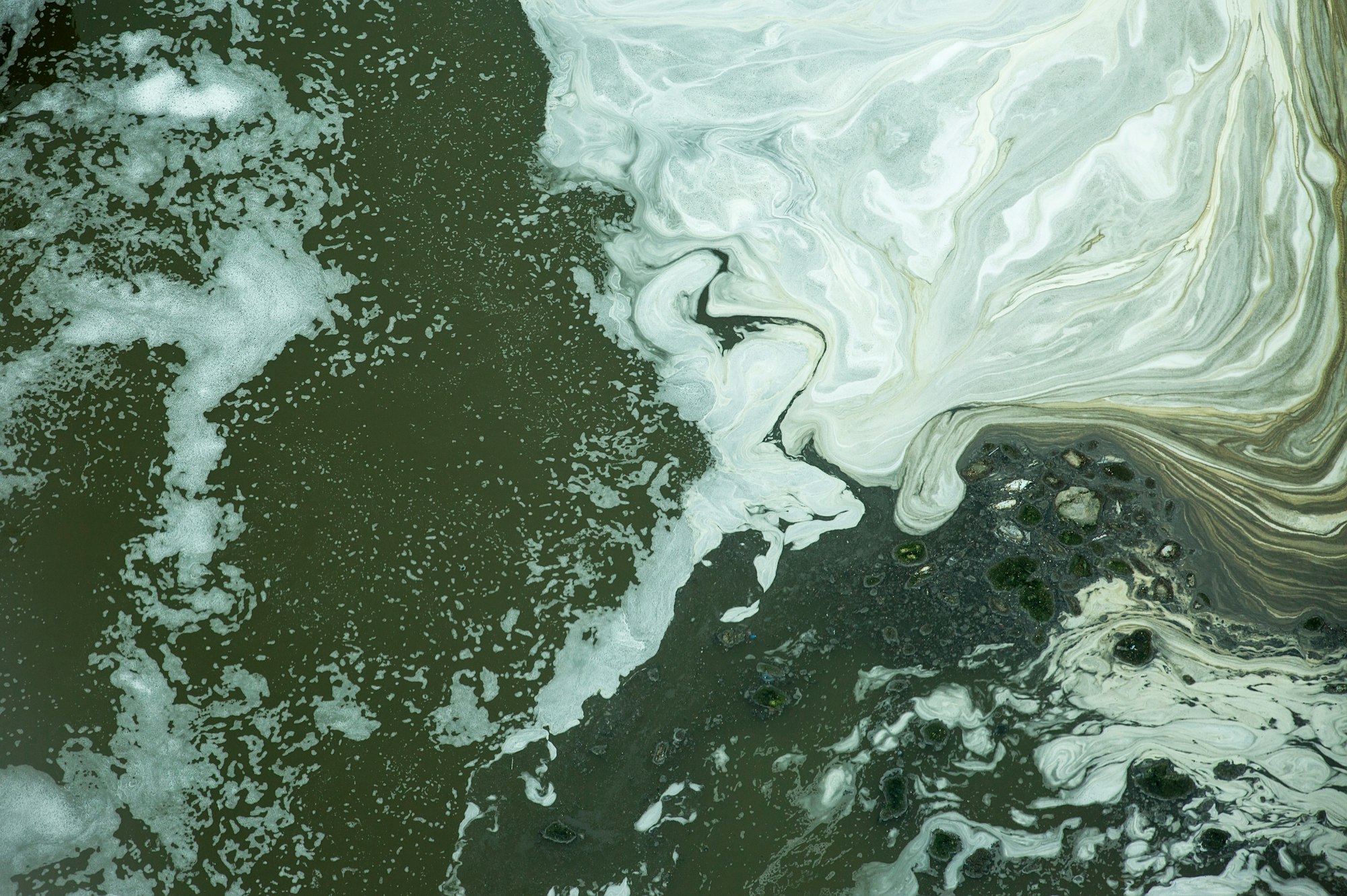 Black water with white bubbles in the waste water treatment pond