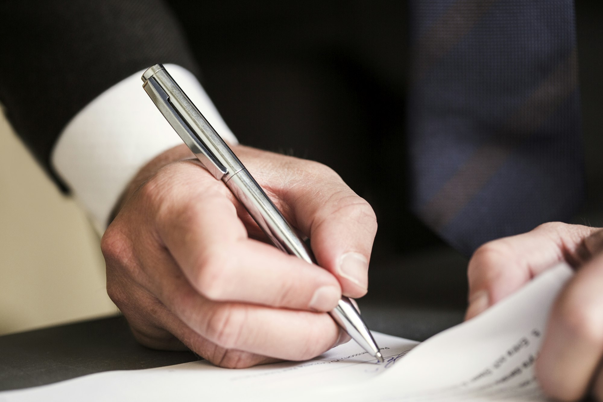 Cropped image of businessman signing document