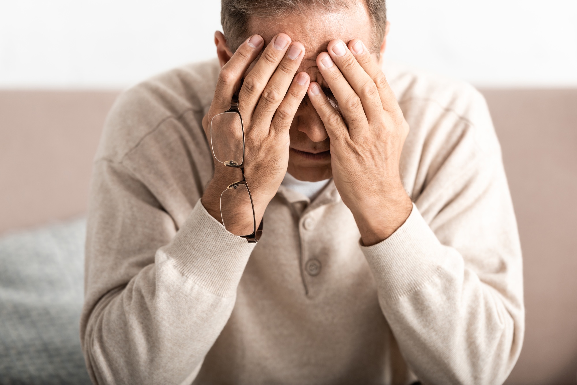 frustrated senior man with alzheimer disease covering face